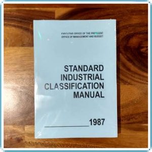 Cover of the "U.S. SIC Manual Softcover," published in 1987 by the Executive Office of the President, Office of Management and Budget, placed on a wooden surface.